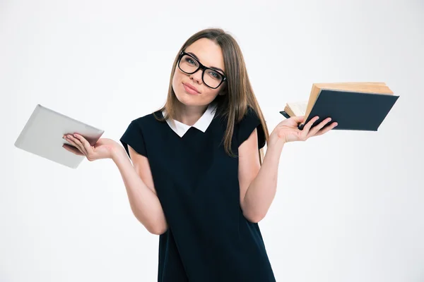 Femme au choix entre tablette et livre — Photo