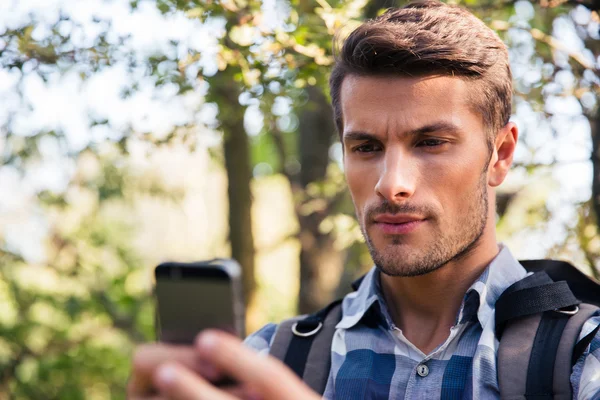 Man using smartphone in the forest — Stock Photo, Image