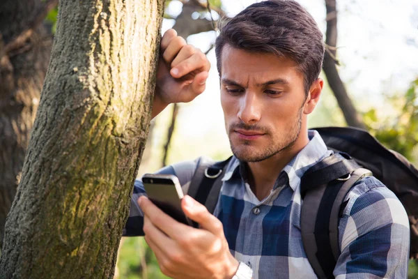 Muž pomocí smartphone v lese — Stock fotografie