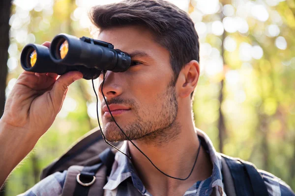 Man op zoek via verrekijker in het forest — Stockfoto