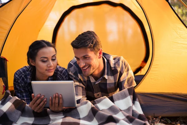 Coppia sdraiata in tenda e utilizzando tablet — Foto Stock