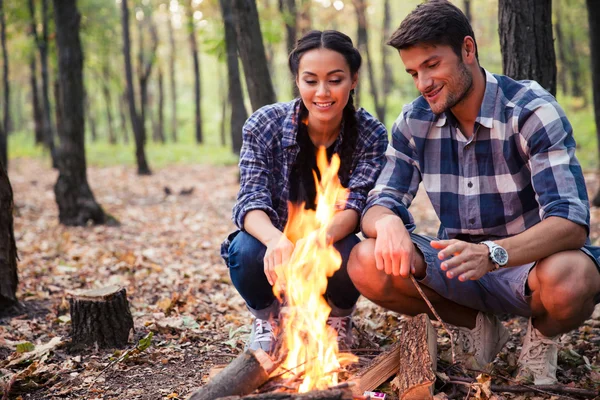 Paar und Lagerfeuer im Wald — Stockfoto