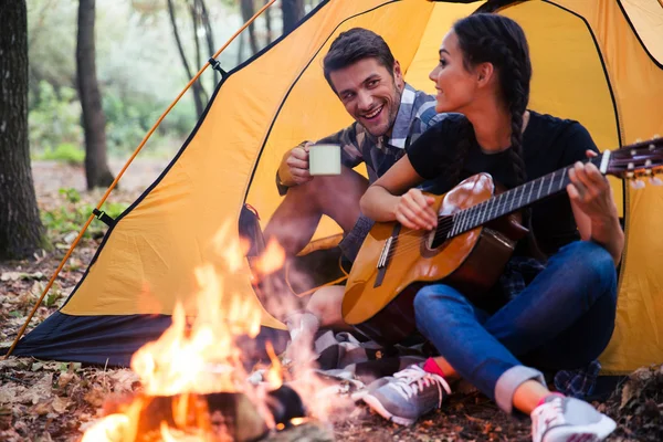 Pár ül közelében tábortűz gitár — Stock Fotó