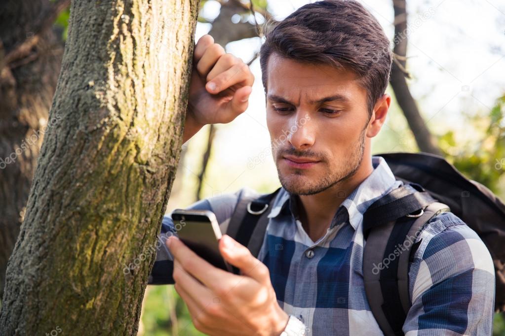 Man using smartphone in the forest