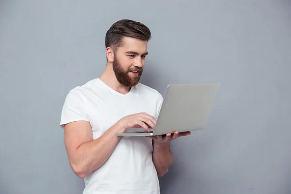 Lachende casual man met laptopcomputer — Stockfoto