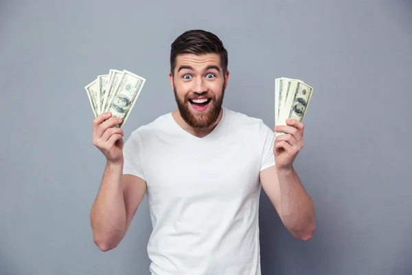 Cheerful man holding dollar bills — Stock Photo, Image