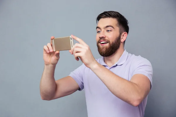 Sorrindo homem fazendo foto no smartphone — Fotografia de Stock