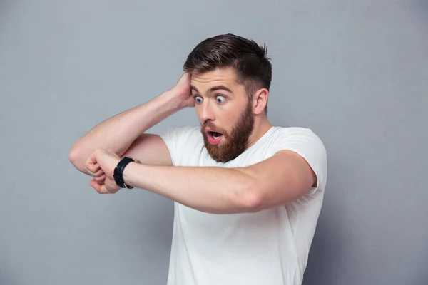 Chockad man ser på armbandsur — Stockfoto