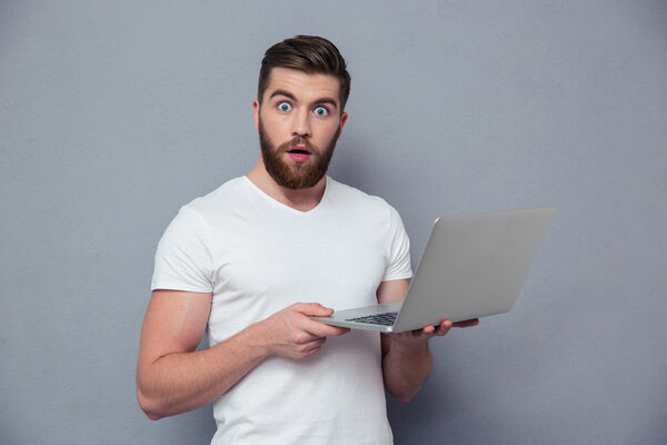 Портрет изумленного человека с ноутбуком
