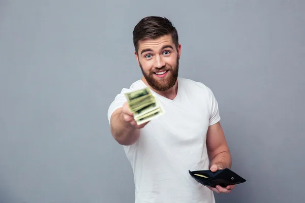 Happy man giving money at camera — Stock Photo, Image