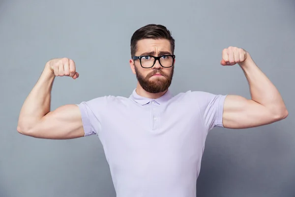 Casual homem de óculos mostrando seu bíceps — Fotografia de Stock