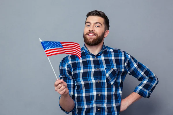 Homme souriant tenant le drapeau des États-Unis — Photo