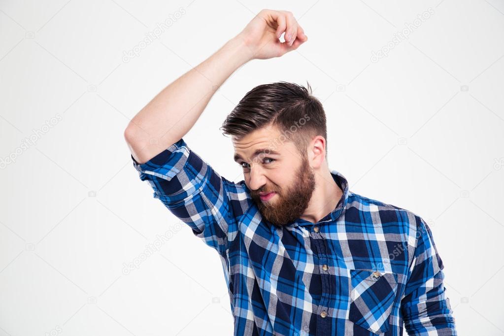 Portrait of a casual man smelling his armpit