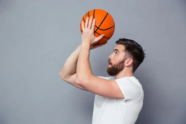 Jeune homme lisant pour lancer une balle de basket — Photo