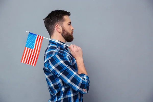 アメリカの国旗を保持しているカジュアルな男の側ビュー肖像 — ストック写真