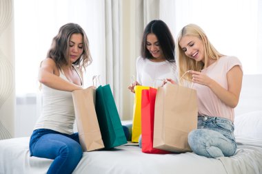 Birçok alışveriş torbaları ile mutlu üç kız