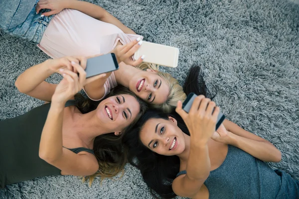 Três namoradas usando smartphones — Fotografia de Stock