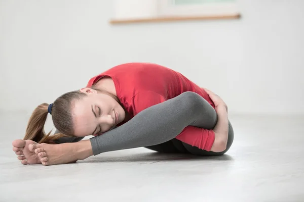 Glad, fleksibel kvinne som gjør yogaøvelser – stockfoto