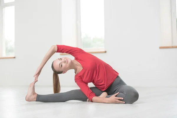 Vrouw doen yoga oefeningen in de sportschool — Stockfoto