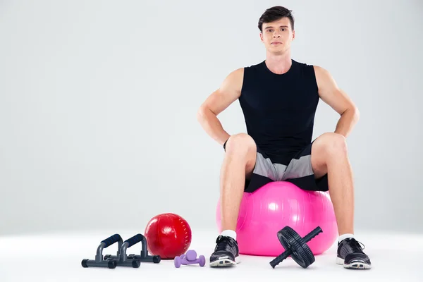 Porträtt av en fitness man sitter på bollen — Stockfoto