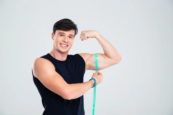 Retrato de um homem de fitness feliz medindo seu bíceps — Fotografia de Stock