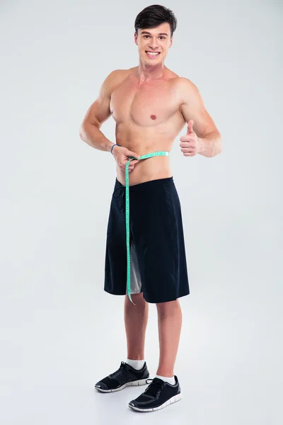 Felice uomo atletico misurare il suo corpo — Foto Stock