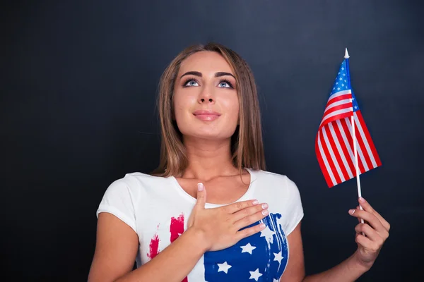 Patriotyczne kobieta trzyma flagę Usa i patrząc w górę — Zdjęcie stockowe