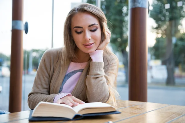 Девочка читает книгу в кафе — стоковое фото