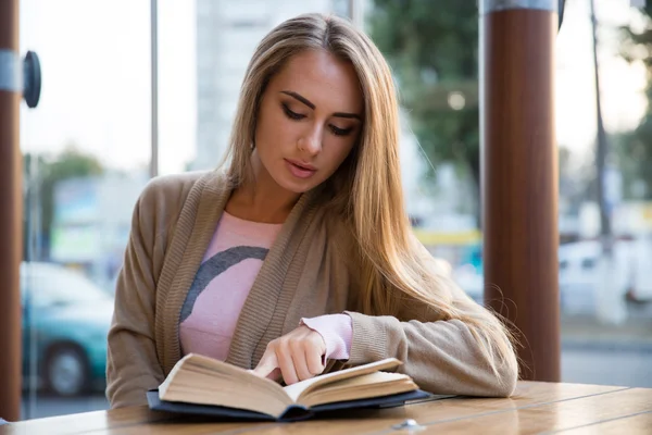 Девочка читает книгу в кафе — стоковое фото
