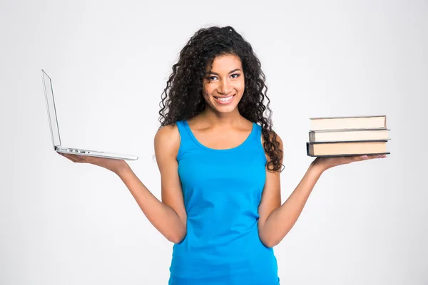 Femme au choix entre ordinateur portable ou livre en papier — Photo