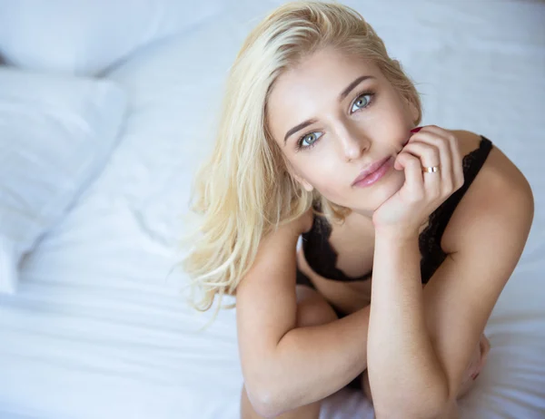 Yatağın üstüne oturan kadın iç çamaşırı büyüleyici kadın — Stok fotoğraf