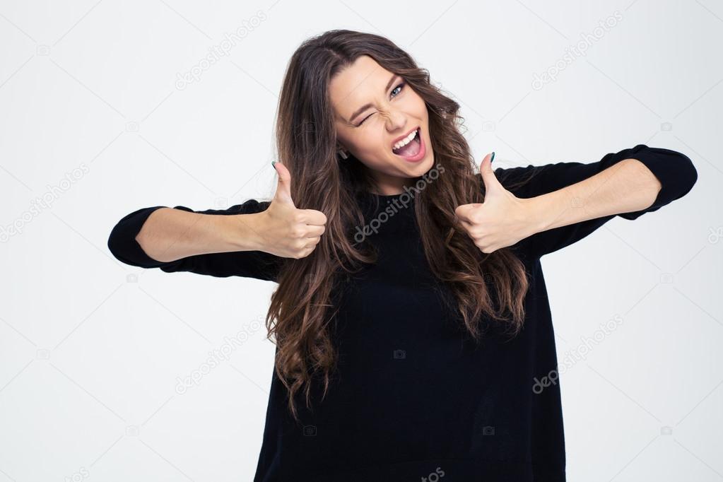 Cheerful woman winking and showing thumbs up