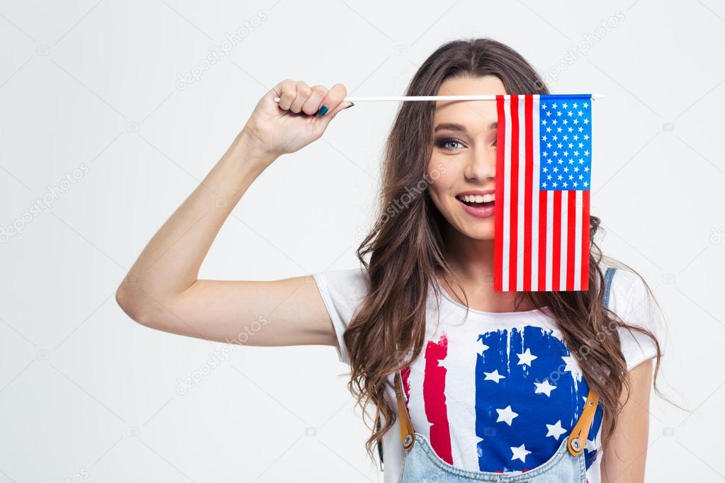 Smiling woman covering her eye with USA flag