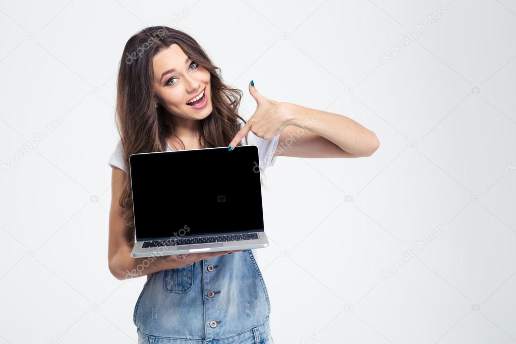 Cheerful girl showing blank laptop computer screen