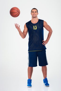 Gülümseyen bir basketbol oyuncusu tam uzunlukta portresi