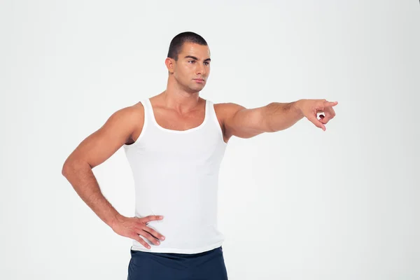 Serious muscular man pointing finger away — Stock Photo, Image