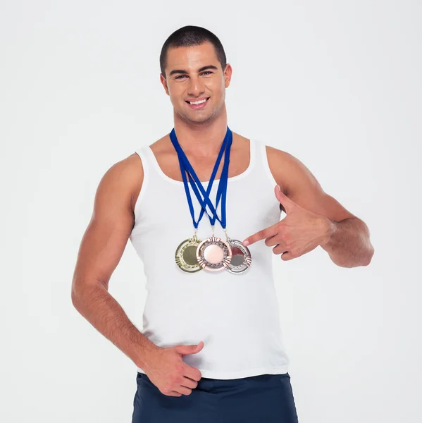 Glücklicher Mann zeigt mit dem Finger auf seine Goldmedaillen — Stockfoto