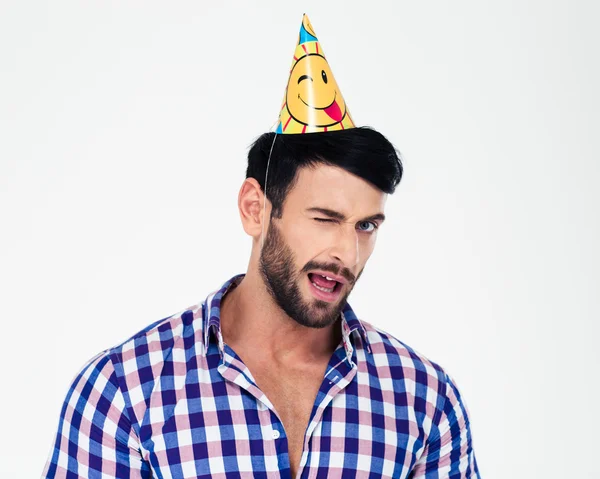 Retrato de um homem bonito em aniversário chapéu piscando — Fotografia de Stock