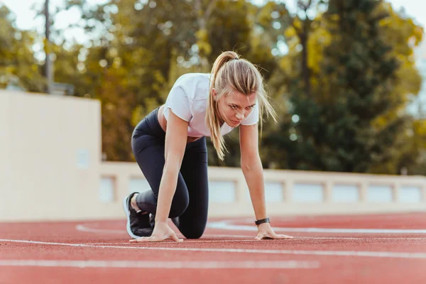 Mujer de pie en posición de salida para correr —  Fotos de Stock