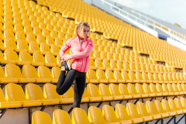 Donna che allunga le gambe allo stadio — Foto Stock