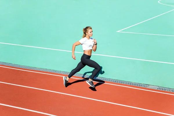 Fitness kvinna kör på stadium — Stockfoto