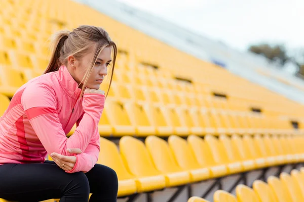 Vrouw in sport slijtage rusten stadium — Stockfoto