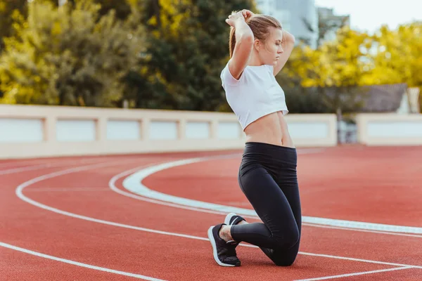 Vrouwelijke atleet rechtzetten haar haar — Stockfoto