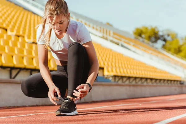 Nő cipőfűzőt szabadtéri stadionban — Stock Fotó