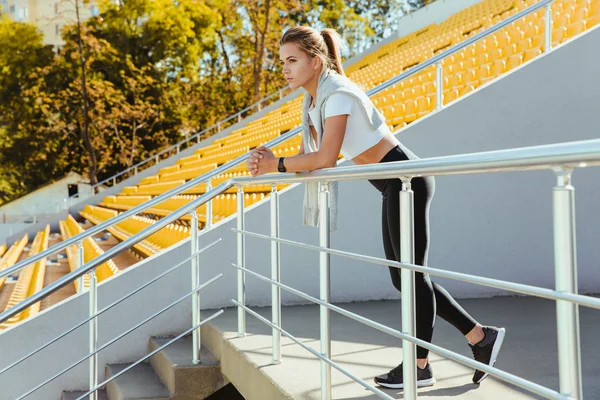 Sportovní žena stojí na stadionu — Stock fotografie