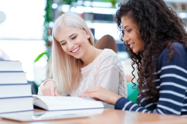 İki kadın okuma kitabı birlikte gülümseyen