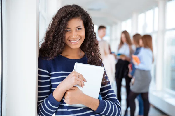 Smiling female student standing in university hall — Stock Photo, Image