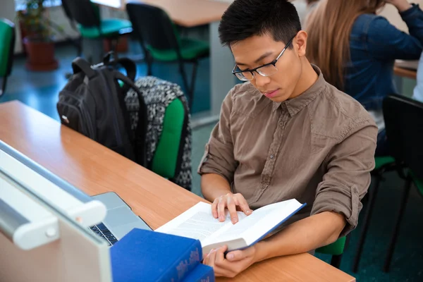 Estudiante masculino leyendo libro en el aula —  Fotos de Stock