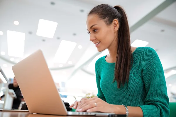 Happy kvinnlig student med laptop i universitet — Stockfoto