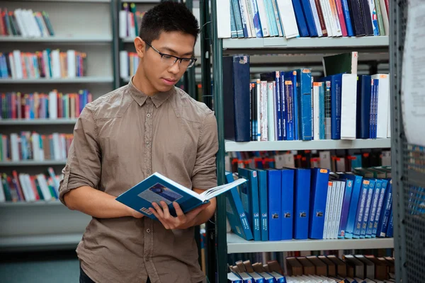 Uczeń czytania książki w bibliotece — Zdjęcie stockowe